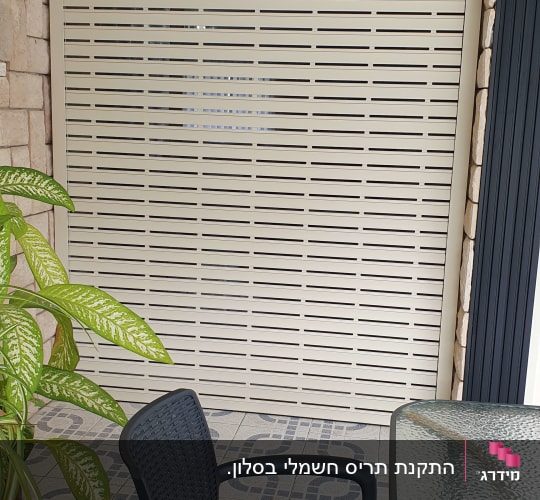 תריס גלילה חשמלי בהיר מותקן במפתח מרפסת עם חיפוי אבן